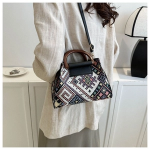Detailed weave of geometric patterns and round wooden handle on ethnic tote bag