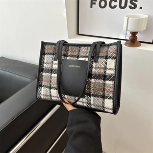 Fashionable black and white plaid tweed tote bag with leather handles and front pocket