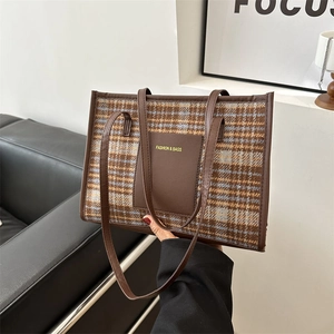 Classic brown plaid tote bag with leather trim and dual straps in a modern room