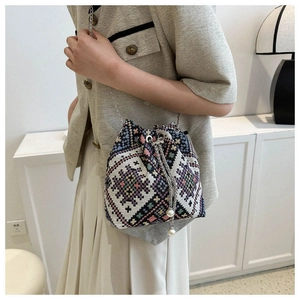 Close-up of ethnic knit bucket bag with colorful geometric patterns and pearl charms