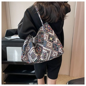 Borsa tote etnica in tela con trama geometrica indossata a spalla da una modella