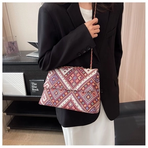 Detail of multi-color geometric ethnic weave shoulder bag with golden chain strap
