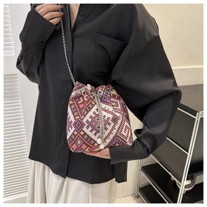 Detailed view of bohemian woven bucket bag featuring diamond patterns and pearl charms