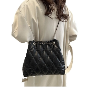 Chic black quilted bucket bag with silver chain strap shown on model for size reference