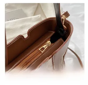 Detail view of the smooth metal zipper and inner compartment of the patchwork bucket bag