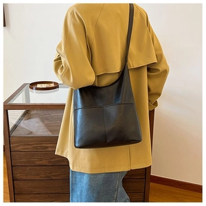 Macro detail of high-quality black faux leather shoulder bag with fine stitching on strap