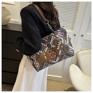 Detail view of ethnic style woven tote bag with colorful patterns and brown leather strap
