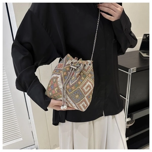 Detail of ethnic canvas bucket bag featuring floral embroidery and pearl drawstring