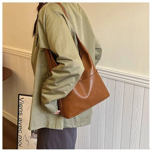 Close-up of caramel leather tote bag with decorative side stitching and matte texture