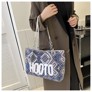 Detail of canvas tote bag with blue geometric ethnic pattern and silver chain strap