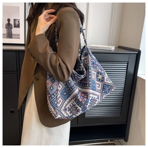 Borsa tote in tela con motivo etnico indossata a spalla con un blazer marrone elegante