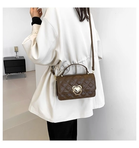Brown quilted crossbody bag featuring a golden heart-shaped lock and chain detail