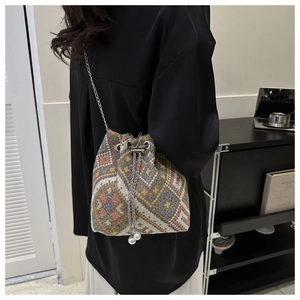 Detail of ethnic canvas bucket bag with geometric jacquard pattern and pearl drawstring