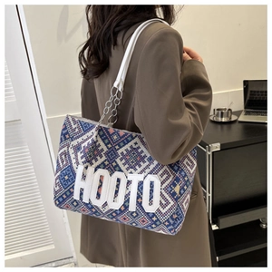 Detail of bohemian geometric canvas tote bag with HOOTO lettering and metal chain strap