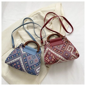 Detail of vintage ethnic tote bags featuring geometric patterns and wooden handles