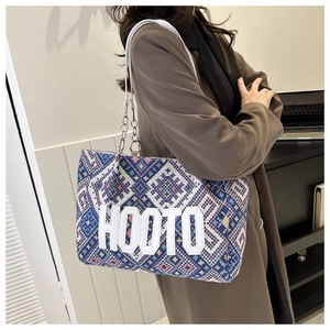 Detail of colorful ethnic tote bag with HOOTO letter patch and chain leather strap