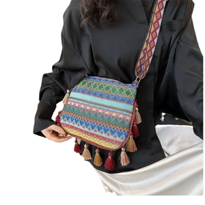 Ethnic bohemian knit bucket bag with colorful tassel fringe and wide shoulder strap