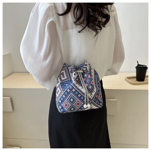 Ethnic canvas bucket bag with colorful geometric patterns and elegant pearl drawstring
