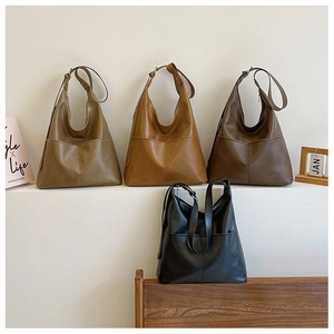 Detailed display of vintage large Hobo bags in four colors on a minimalist stage