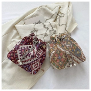 Detail of ethnic geometric woven bucket bags with silver chains and pearl drawstrings