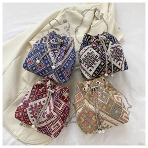 Top view of four bohemian canvas bucket bags with geometric weaving and pearl chains