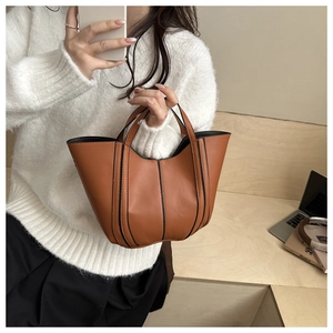 Détail d'un sac seau marron avec contour noir décoratif et bords en forme de vagues