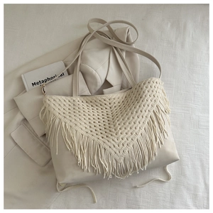 Close-up of cream-colored tote bag featuring bohemian crochet fringe tassels on front