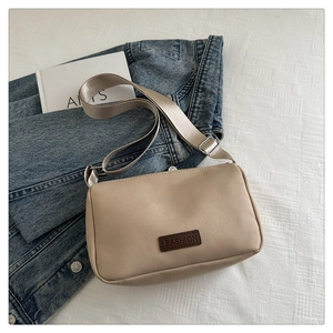 Détail d'un sac à main beige en toile avec patch en cuir et bandoulière tissée