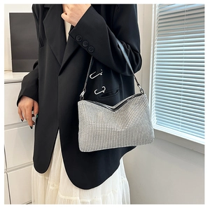 Detail of silver rhinestone crescent hobo bag with sparkling crystals and black leather strap