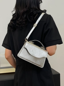 Silver metallic crossbody party bag with top handle and chain strap on black background
