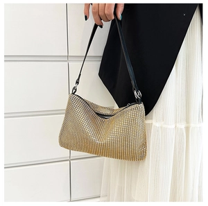 Close-up of gold rhinestone handbag featuring high-density crystals and black leather strap