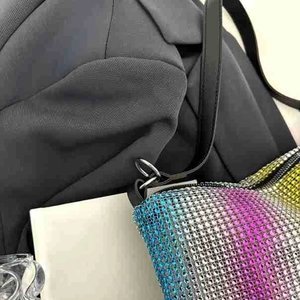 Detail of gradient rhinestones in blue and purple on a stylish shoulder bag with strap