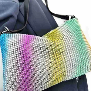 Macro detail of gradient rhinestone handbag showing rows of colorful crystals and strap