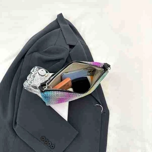 Detail showing the internal storage of a rainbow gradient rhinestone evening bag
