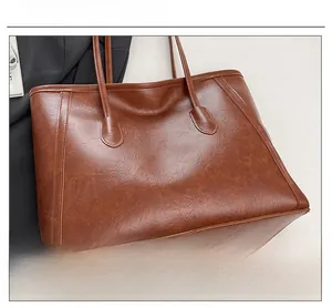 Dettaglio della pelle cerata marrone e delle cuciture fini di questa borsa tote