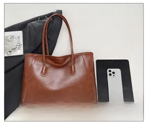 Vista dall'alto della grande borsa tote marrone vintage con tablet e oggetti