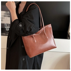 Dettaglio della borsa tote vintage marrone scuro con trama a grana fine e cuciture eleganti