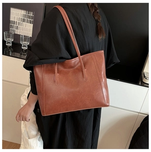 Dettaglio della borsa tote marrone vintage con trama in pelle e cuciture decorative