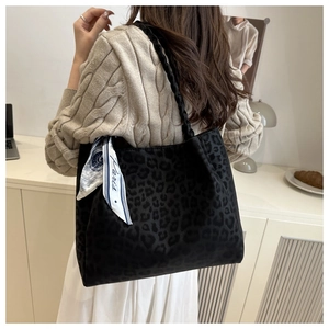 Detail of leopard print tote bag with white Paris silk scarf accessory on a model