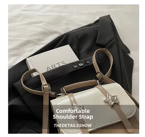 Détail des bretelles réglables sur un sac à dos bicolore en similicuir beige et blanc