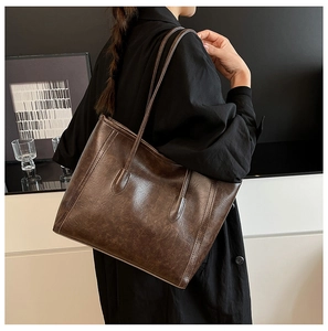 Dettaglio di una grande borsa tote vintage marrone scuro con trama in ecopelle fine