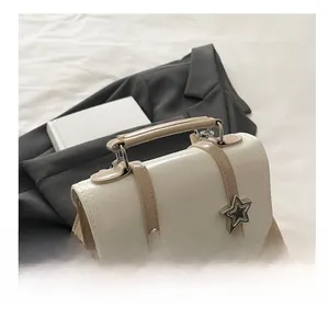 Vue détaillée de la poignée du sac à dos et des boucles en étoile sur tissu beige