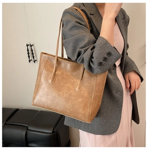 Dettaglio della borsa tote marrone vintage con doppi spallacci e texture rustica