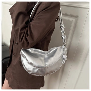 Detail of silver metallic hobo bag with knotted strap and pearl bead charm accessory
