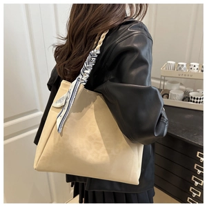 Detailed side view of a beige leopard texture tote bag with a patterned silk scarf handle