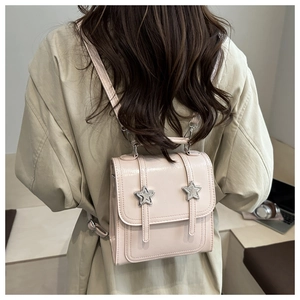 Détail du mini sac à dos en cuir verni rose clair avec des étoiles argentées décoratives