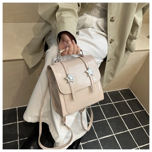 Détail d'un mini sac à dos beige avec étoiles argentées et bretelles réglables