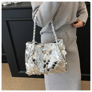 Close-up of a silver sequined shoulder bag featuring braided handles and metallic details