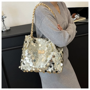 Detail of gold oversized sequins on tote bag with metallic chain and leather logo tag