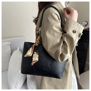 Vue détaillée du sac cabas en simili cuir noir avec un foulard en soie à motif géométrique